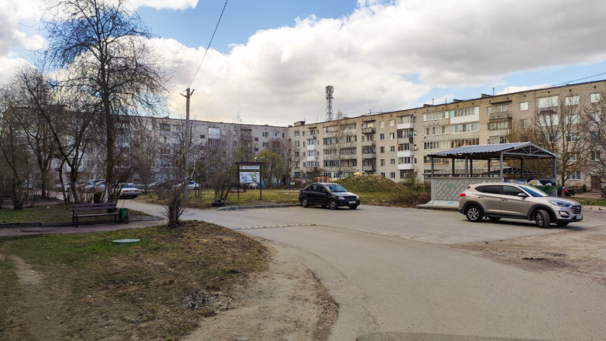 Двор жилого дома с зелеными насаждениями и автомобилями