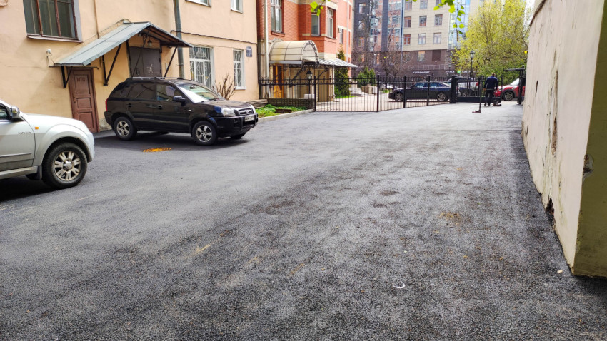 Свежий асфальт на парковке жилого дома в городе