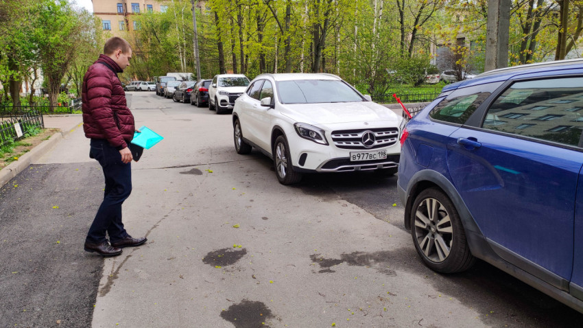 Мужчина изучает припаркованный автомобиль на улице