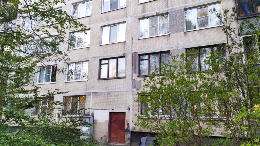 Жилой дом в зеленом районе города с большими окнами