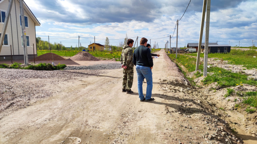 Люди стоят на дороге в сельской местности под облачным небом