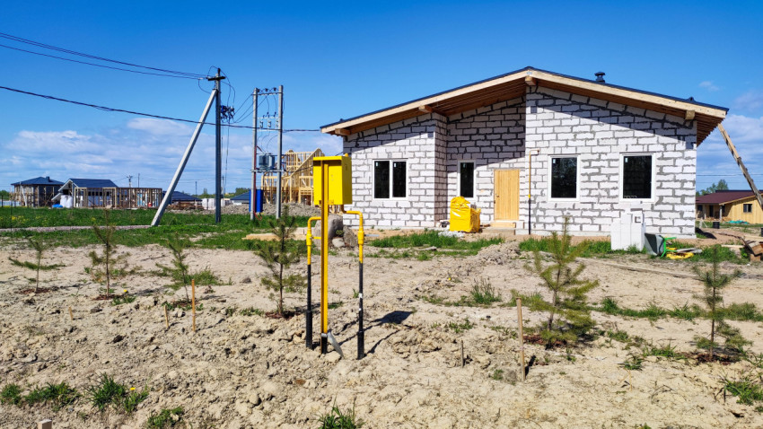 Газовая коробка на фоне дома, строящегося в пригороде