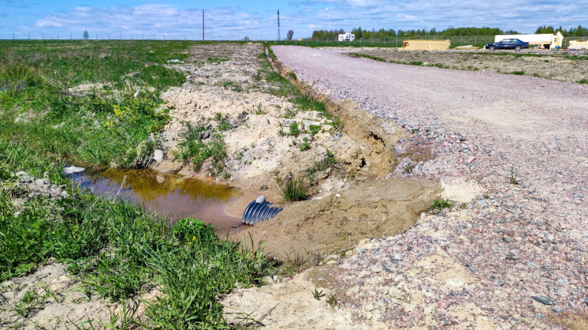Дренажная труба под дорогой в загородной местности