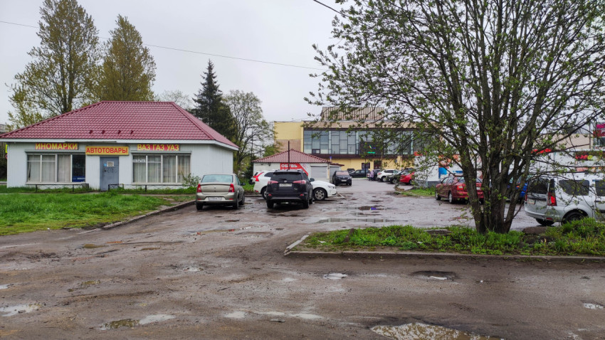 Разбитая дорога и парковка в городском районе в дождливый день
