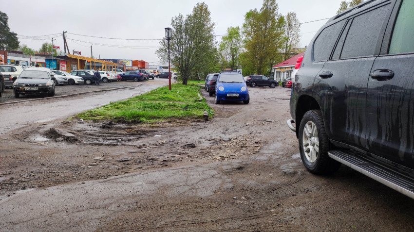 Парковка с грязью и автомобилями в дождливый день в городе