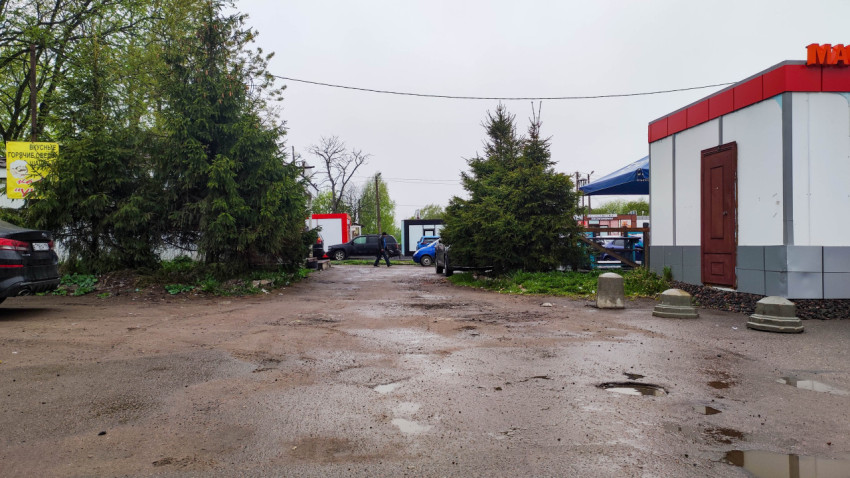 Пейзаж парковки у магазина в сером свете дождливого дня