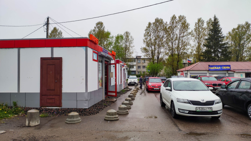 Торговый павильон и парковка возле жилых зданий в дождливую погоду