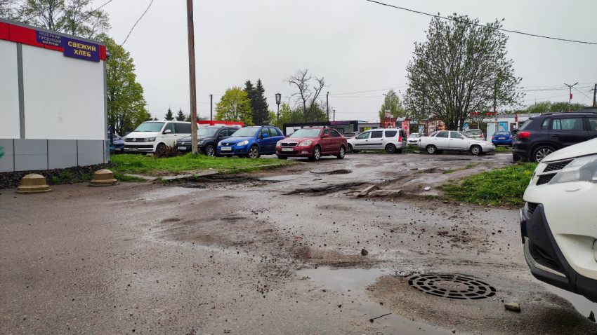 Парковка с поврежденным асфальтом в дождливую погоду