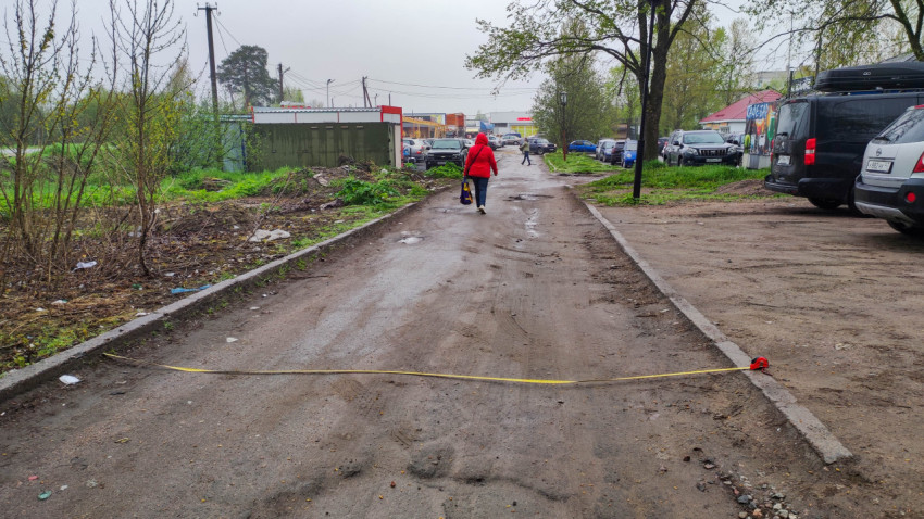 Измерение ширины дороги с помощью рулетки на узкой улице