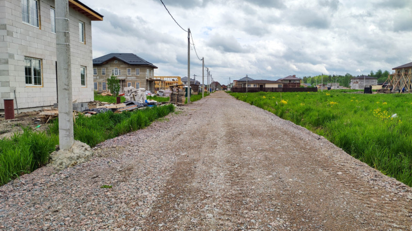 Новая дорога в загородной местности с домами и облачным небом