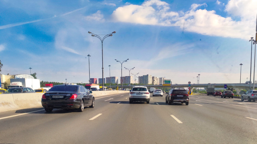 Движение автомобилей по городской магистрали в ясный день