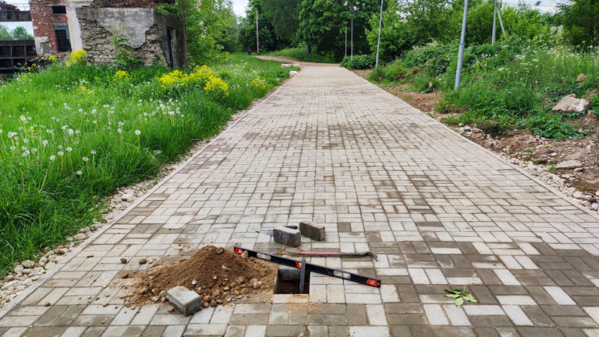 Измерение глубины основания под тротуарной плиткой на дорожке