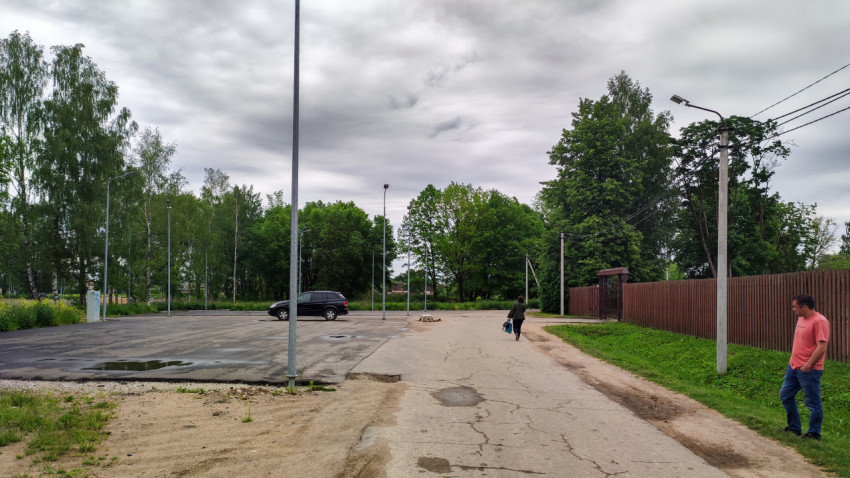Новая парковка автомобилей рядом с зеленым парком