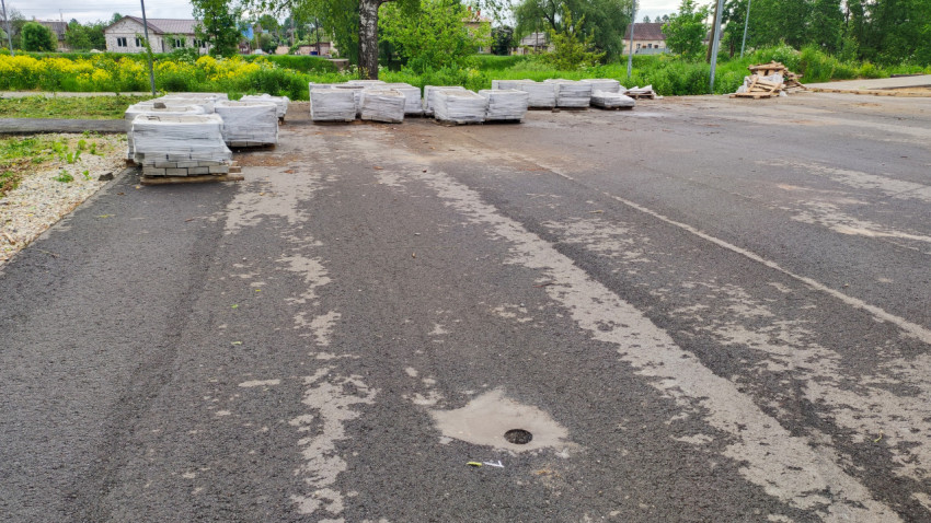 Асфальтированный участок парковки с паллетами с тротуарной плиткой