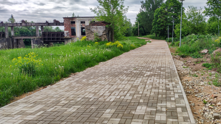 Дорожка вдоль заброшенного здания в зеленом парке
