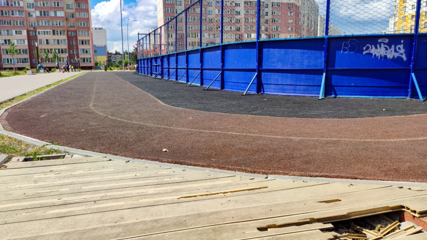 Сломанное деревянное покрытие возле хоккейной коробки в городе