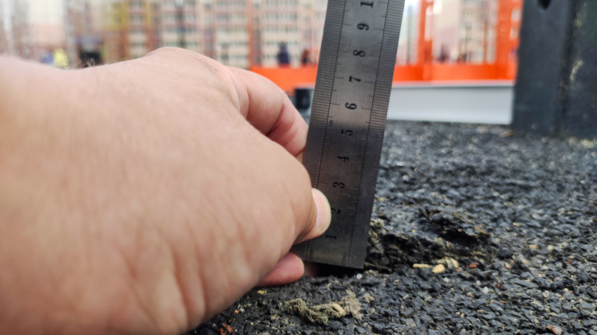 Измерение повреждённого участка резинового покрытия на площадке