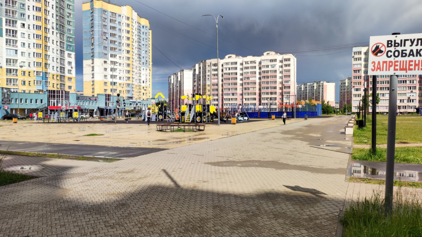 Детская площадка в городе с серым небом и играющими детьми