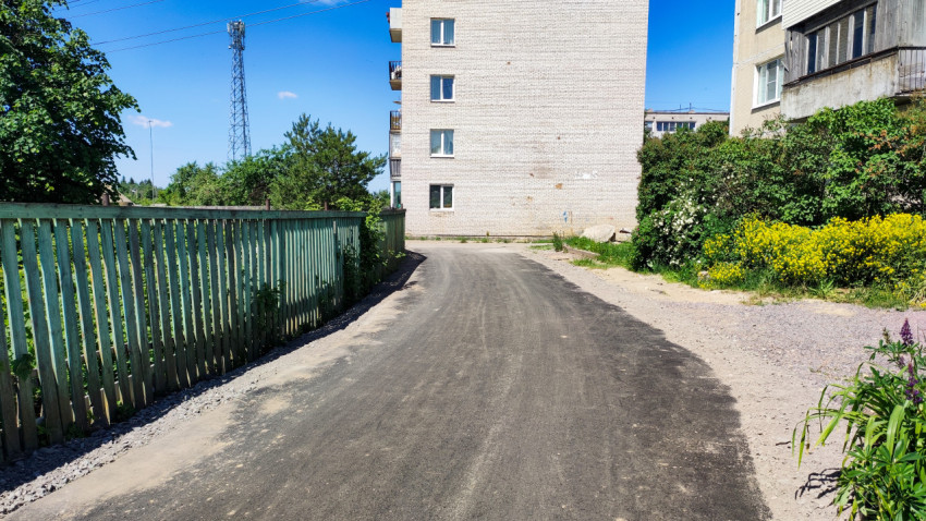 Новый асфальт на улице рядом с жилым домом в солнечный день