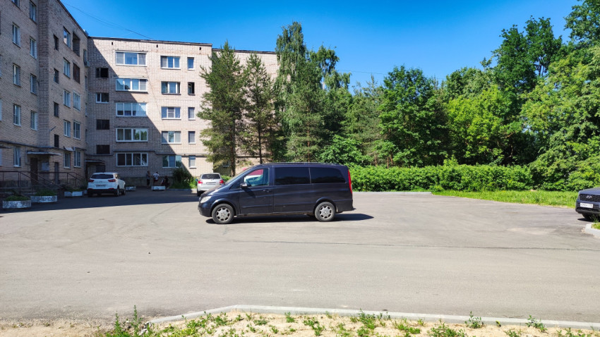 Микроавтобус стоит на парковке жилого комплекса в солнечный день