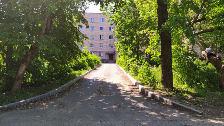 Путь к пятиэтажному зданию под солнцем