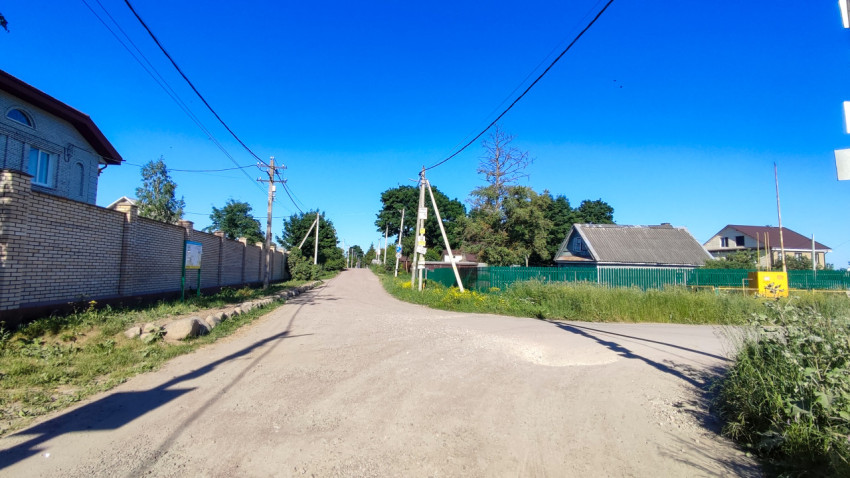Перекресток двух дорог в поселке под ясным небом в летний день