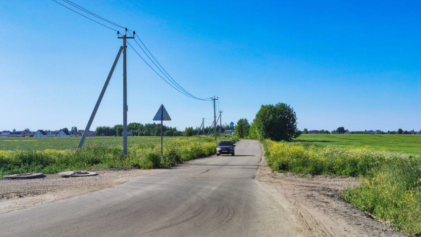 Дорога через поля в сельской местности под ясным небом