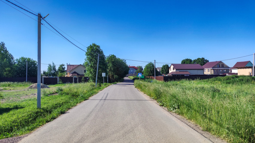 Пейзаж пустой дороги в поселке под солнечным небом