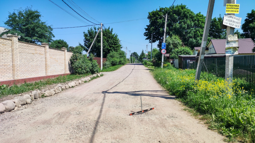 Измерение глубины ямы на грунтовой дороге в солнечный день