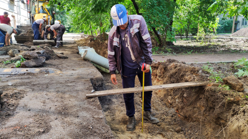 Измерение глубины траншеи во время строительных работ
