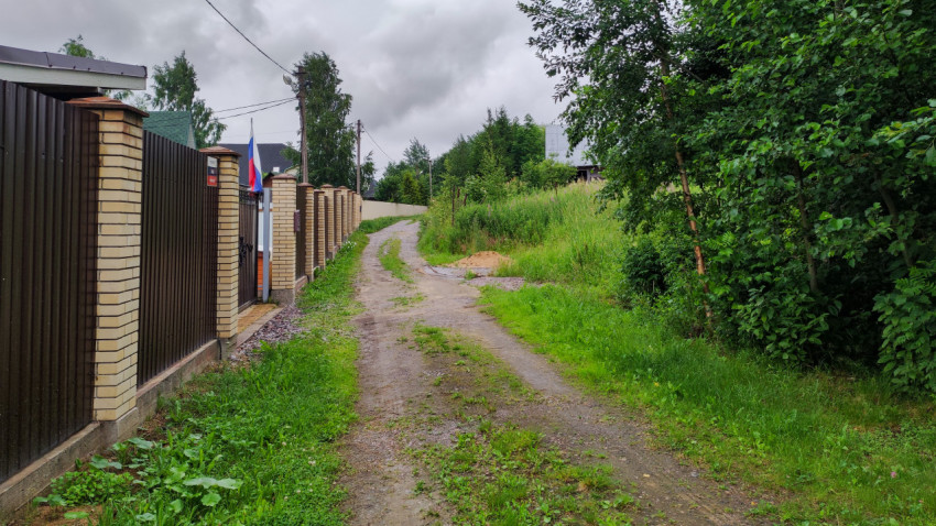 Дорога рядом с забором в загородном поселке