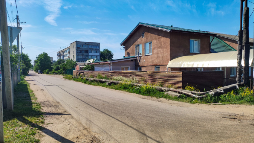 Улица небольшого города с домами и зелеными насаждениями