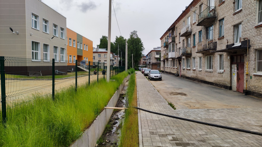 Дренажная канава вдоль дороги в жилом районе за городом