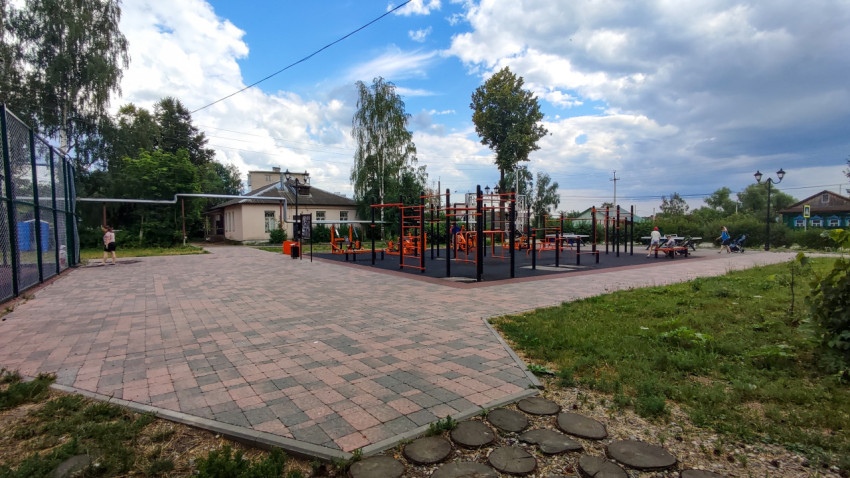 Спортивная площадка в деревне на фоне облачного неба и зелени