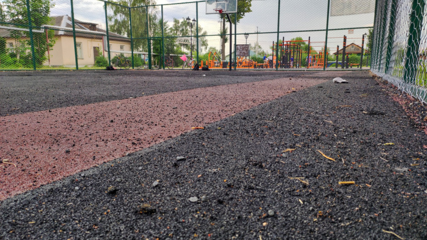 Резиновое покрытие на игровой площадке рядом со спортивной площадкой