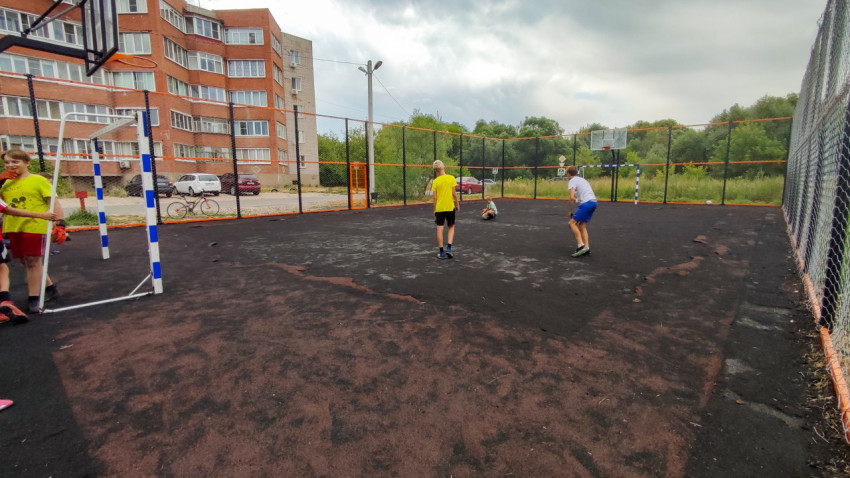 Поврежденное резиновое покрытие на футбольном поле в жилом дворе