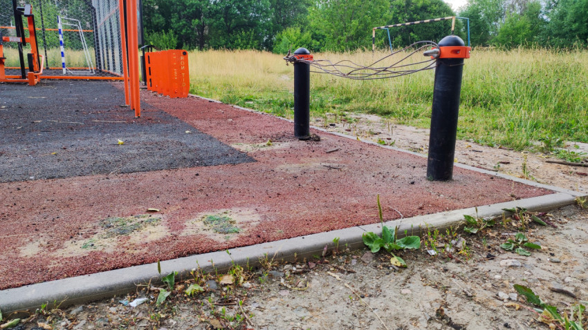 Поврежденное резиновое покрытие и мусор на спортивной площадке