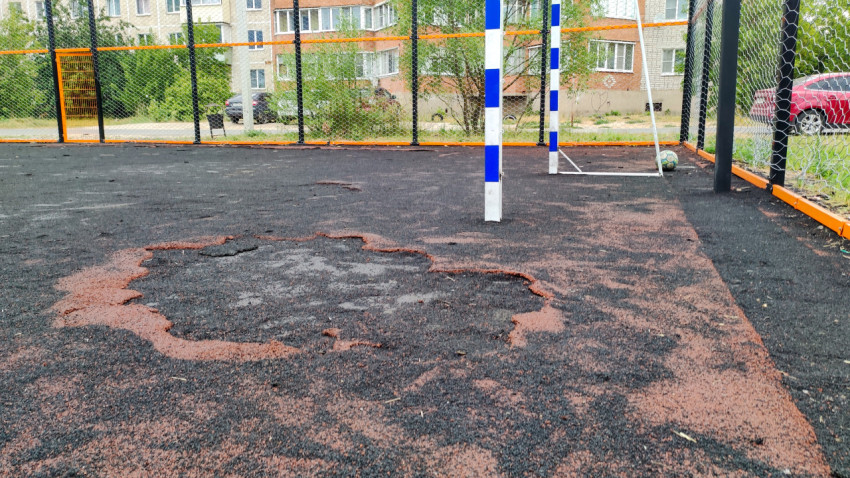 Повреждённое резиновое покрытие на футбольном поле в городе