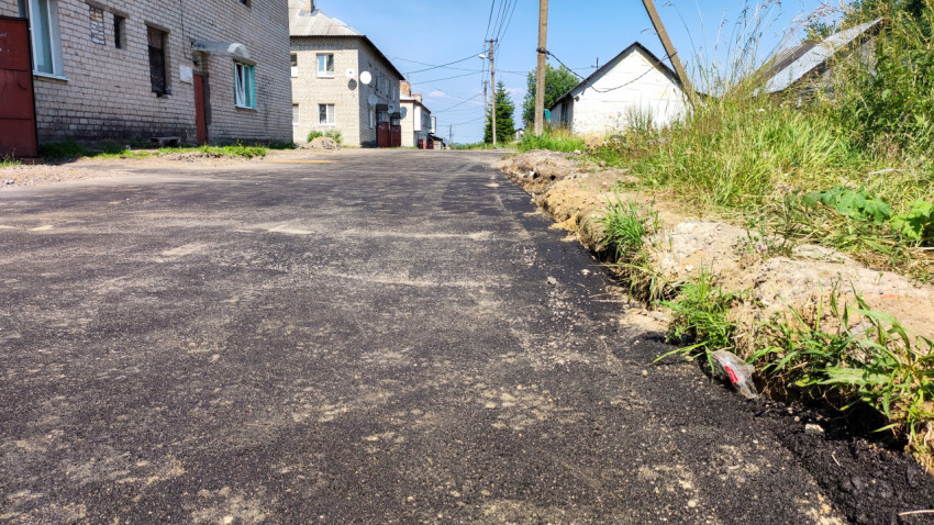 Новый асфальт на дороге в поселке в солнечный день
