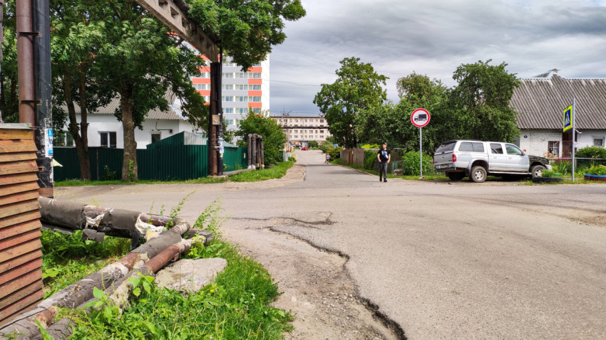 Улица в городском районе, человек идет по дороге