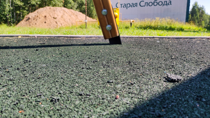 Резиновое покрытие с мелким мусором и резиновыми крошками на площадке