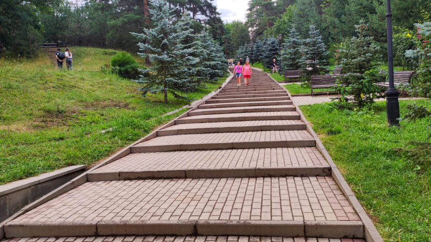 Прогулка по красивым ступеням парка в Кисловодске с зелеными деревьями