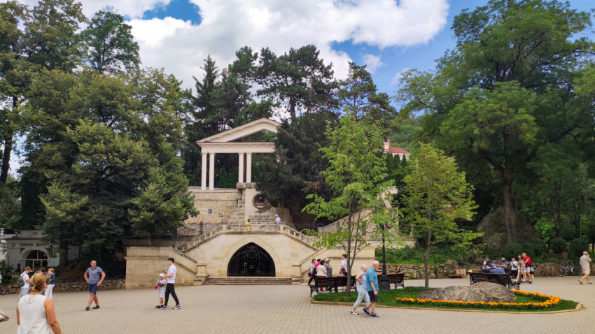 Памятник Лермонтову в Кисловодске на фоне зелени и облаков