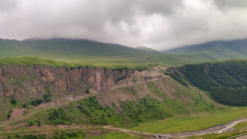 Красивый горный пейзаж с облаками и зеленой долиной