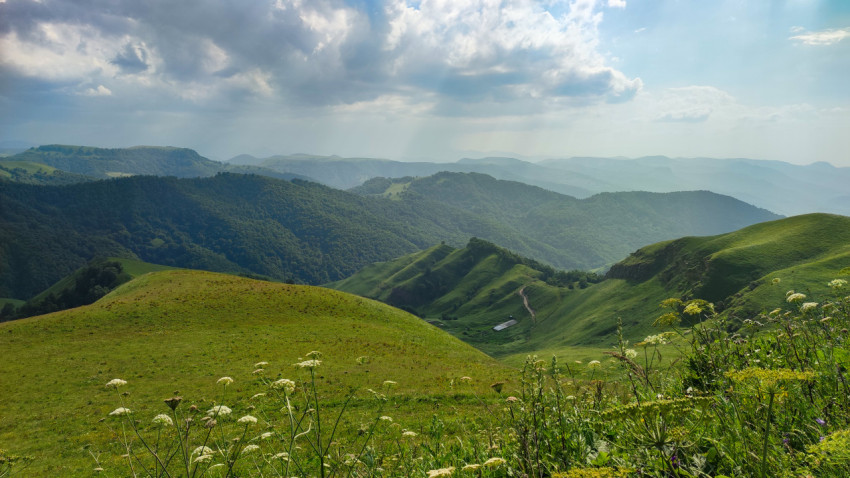 Горы Кавказа с зелеными холмами и облачным небом