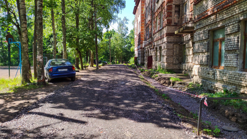 Грунтовая дорога с защитной лентой во дворе жилого дома