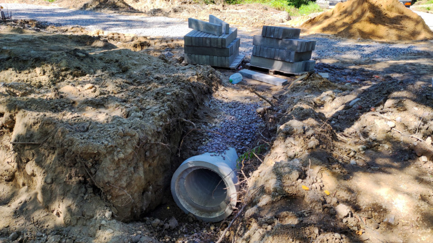Стройплощадка с бордюрами и водоотводом под дорогой