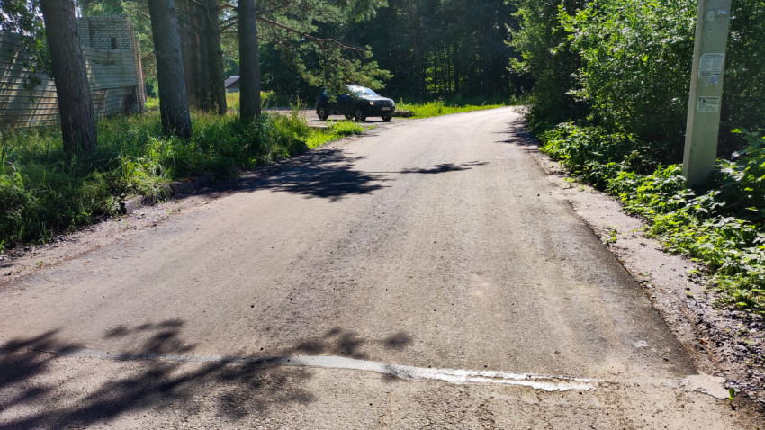 Свежеуложенная дорога в лесной местности недалеко от города