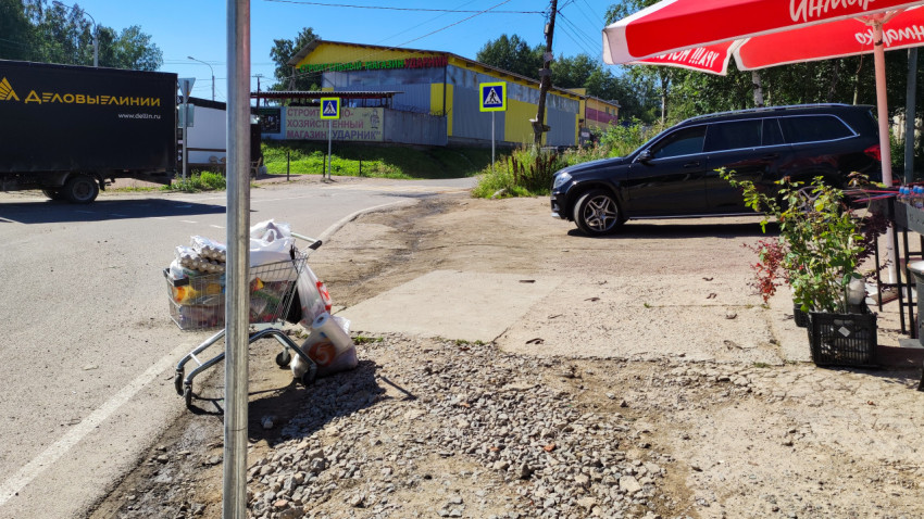 Улица с тележкой для покупок и припаркованным автомобилем
