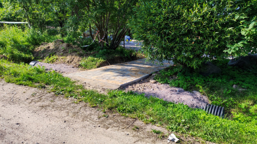 Новый тротуар с плиткой, ведущий к детской площадке